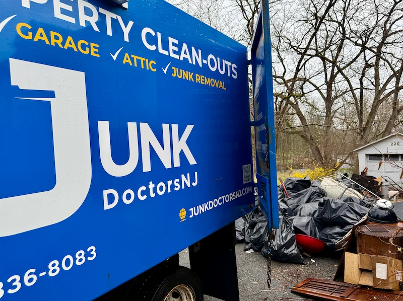 A massive pile of bagged garbage and household debris left outside a residential property, ready to be hauled away by a Junk Doctors truck after an eviction.