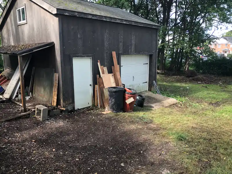 The same Phillipsburg, New Jersey backyard fully cleared of all hoarder junk and debris by the Junk Doctors team, restoring access to the garage and shed.