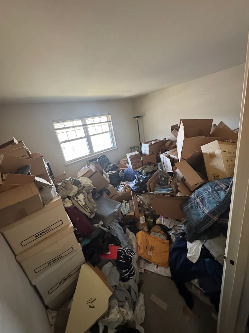 Professional hoarding cleanup services in Rockaway, New Jersey showing a room with heavy accumulation before JunkDoctors began removal.
