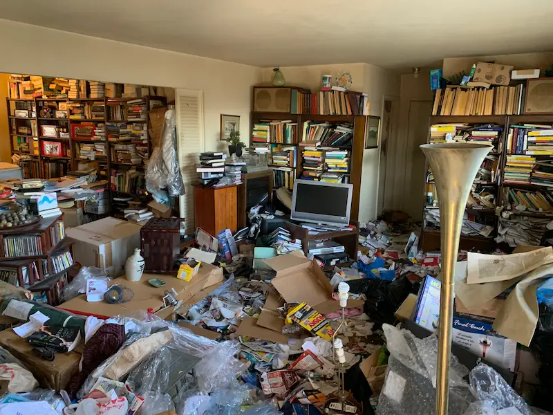 Before photo of a selective hoarding cleanup service in Marlboro, New Jersey, a home, showing heavy floor clutter and paper accumulation before Junk Doctors began removal.