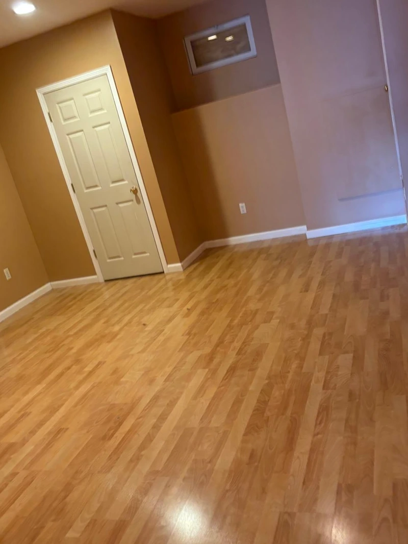 An empty finished basement room after JunkDoctors hauled away a heavy treadmill in Ridgewood, New Jersey.